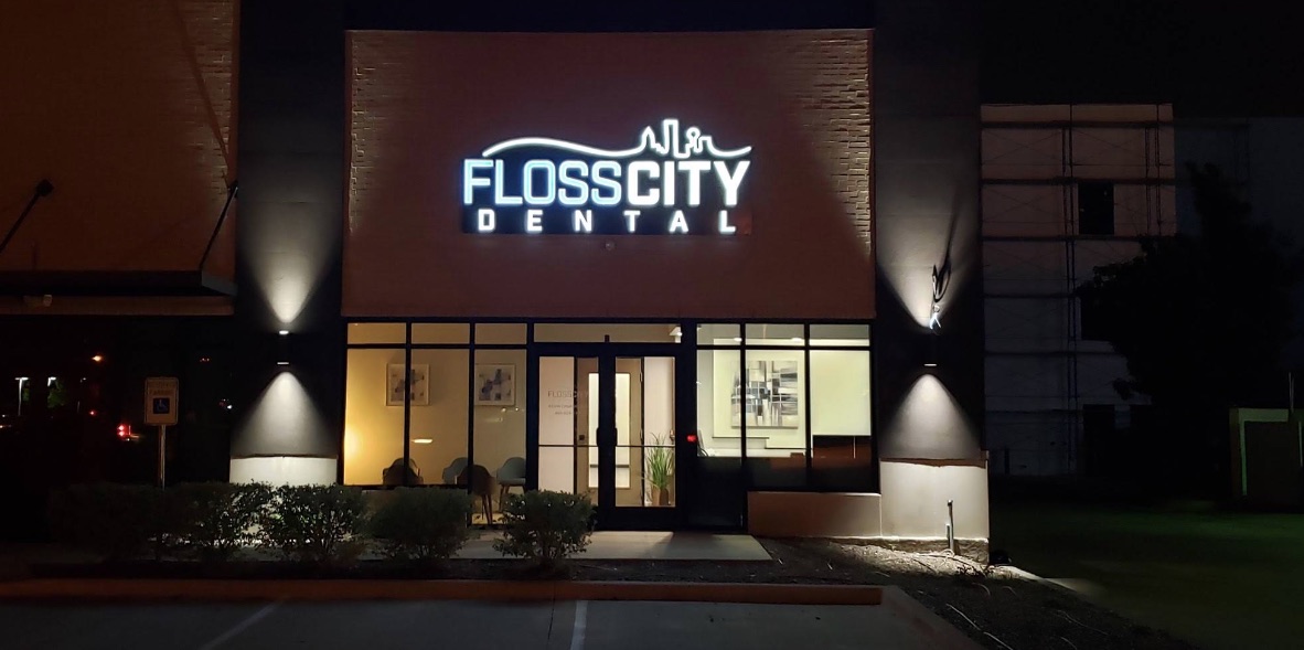 The Floss City Dental entrance and lit sign in the evening, Plano, TX